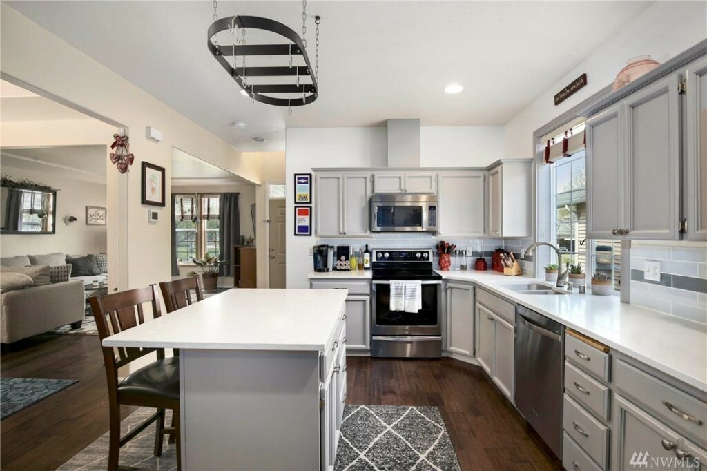 When choosing countertop materials for families you really can't go wrong with quartz. A modern quartz family kitchen with tile backsplash and an island eating bar.