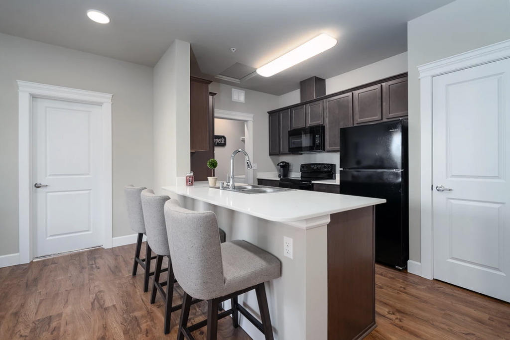 Senior living countertop design considerations require different layouts than standard multifamily apartments. For example, the countertops and bar stool setup pictured here might be too high for comfort or safety of senior citizens. 