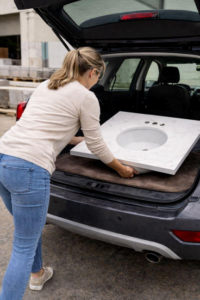 A woman loading up a small marble DIY bathroom vanity countertop