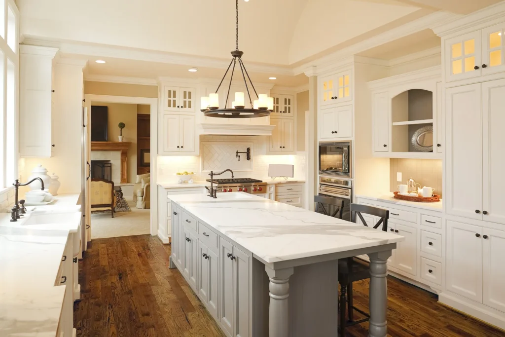 White Calacatta marble countertops with a gray island and white subway tile backsplash