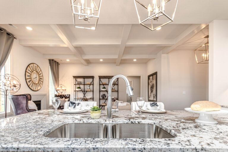 White granite kitchen island with black and gray specks and an undermount stainless double sink