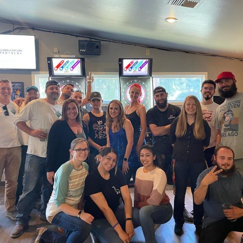 Large group of Tops Countertops team members smiling together at a team night out