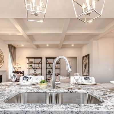 Mid-century modern style kitchen with light granite countertops, chrome fixtures.