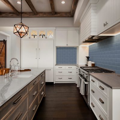 TOPS Kitchen Remodel: Mid-century modern style kitchen with quartz countertops, white cabinets and blue subway tile backsplash.